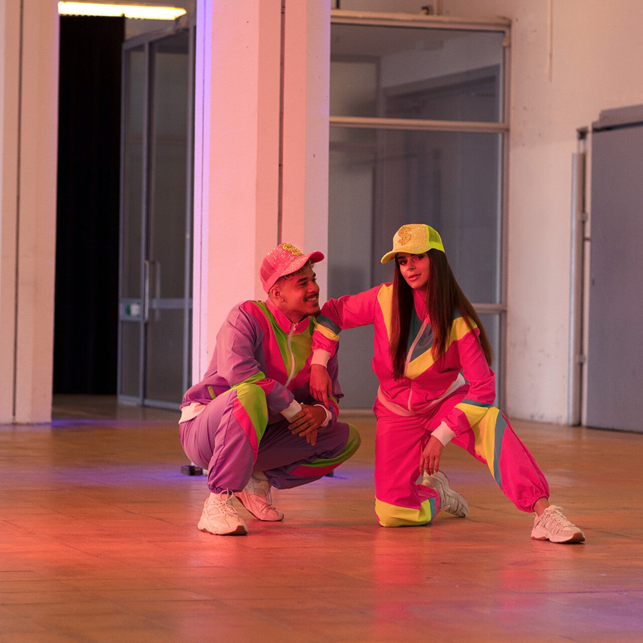 Op deze afbeelding zie je een Kostuums, van het merk Boland. Trainingspak Retro Babe Neonroze Vrouw Kostuum